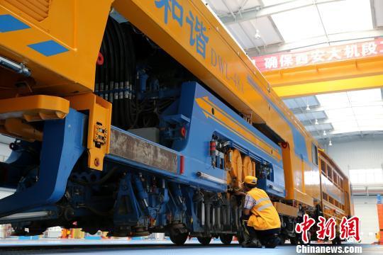 圖為工人正在清理大型養(yǎng)路機(jī)械?！堖h(yuǎn) 攝